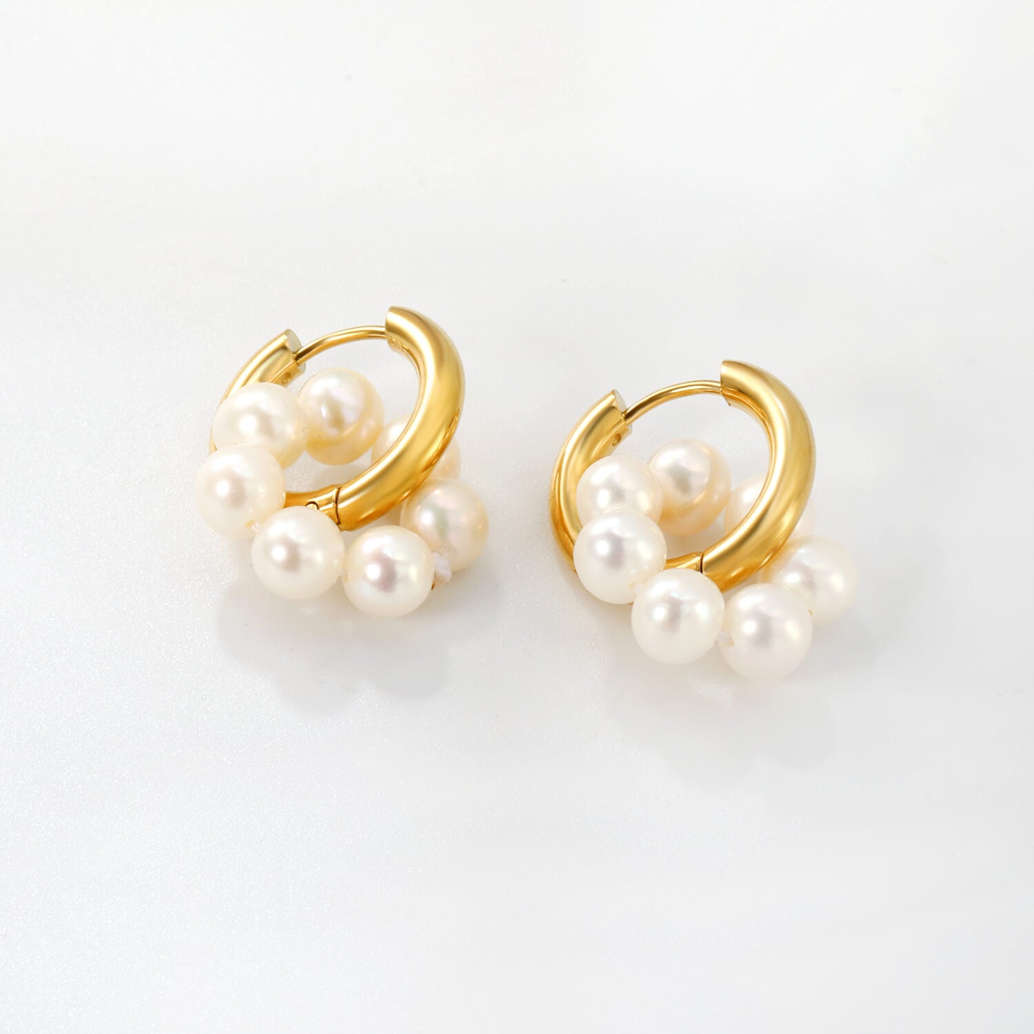 Tuotekuva kullatuista helmikorvakoruista valkoista taustaa vasten