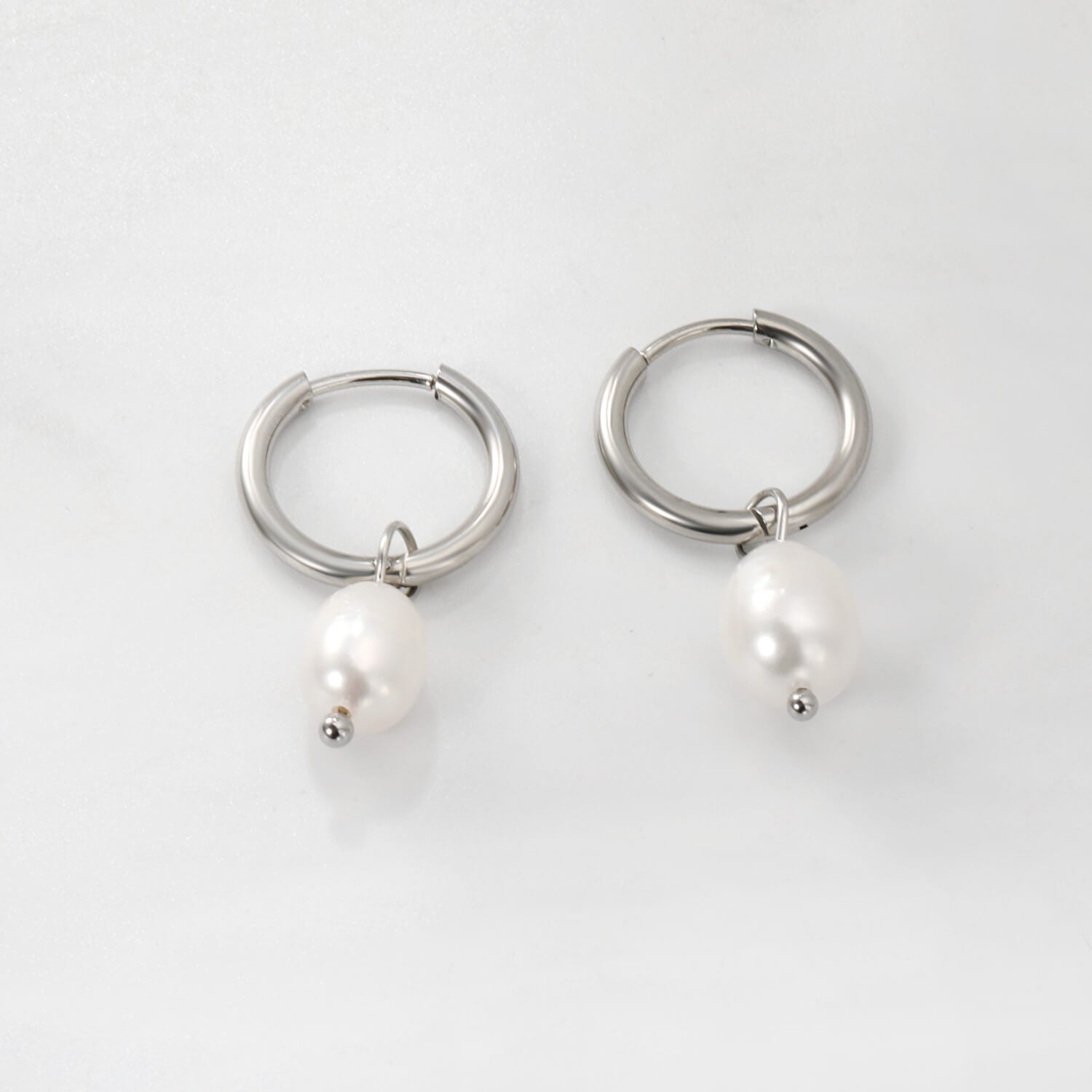 Hopeiset helmikorvakorut jossa makeanvedenhelmet