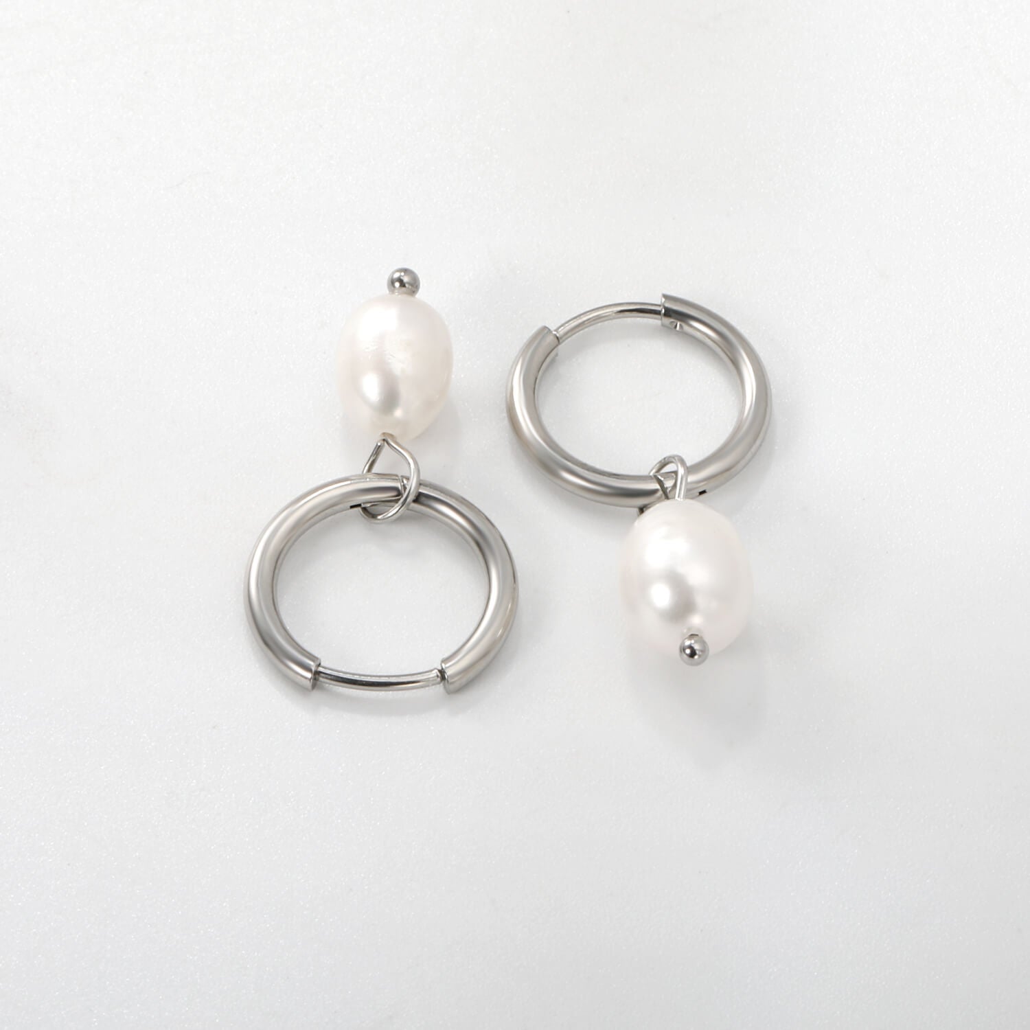 Hopeiset helmikorvakorut jossa yksi helmi