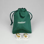 Aqua circle kullatut helmikorvakorut satiinipussin edessä