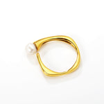 Kultainen säädettävä helmisormus valkoisella taustalla.