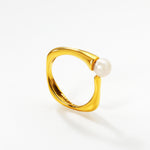 Helmisormus, valkoisella taustalla. Kultainen säädettävä sormus jossa yksi makeanvedenhelmi.