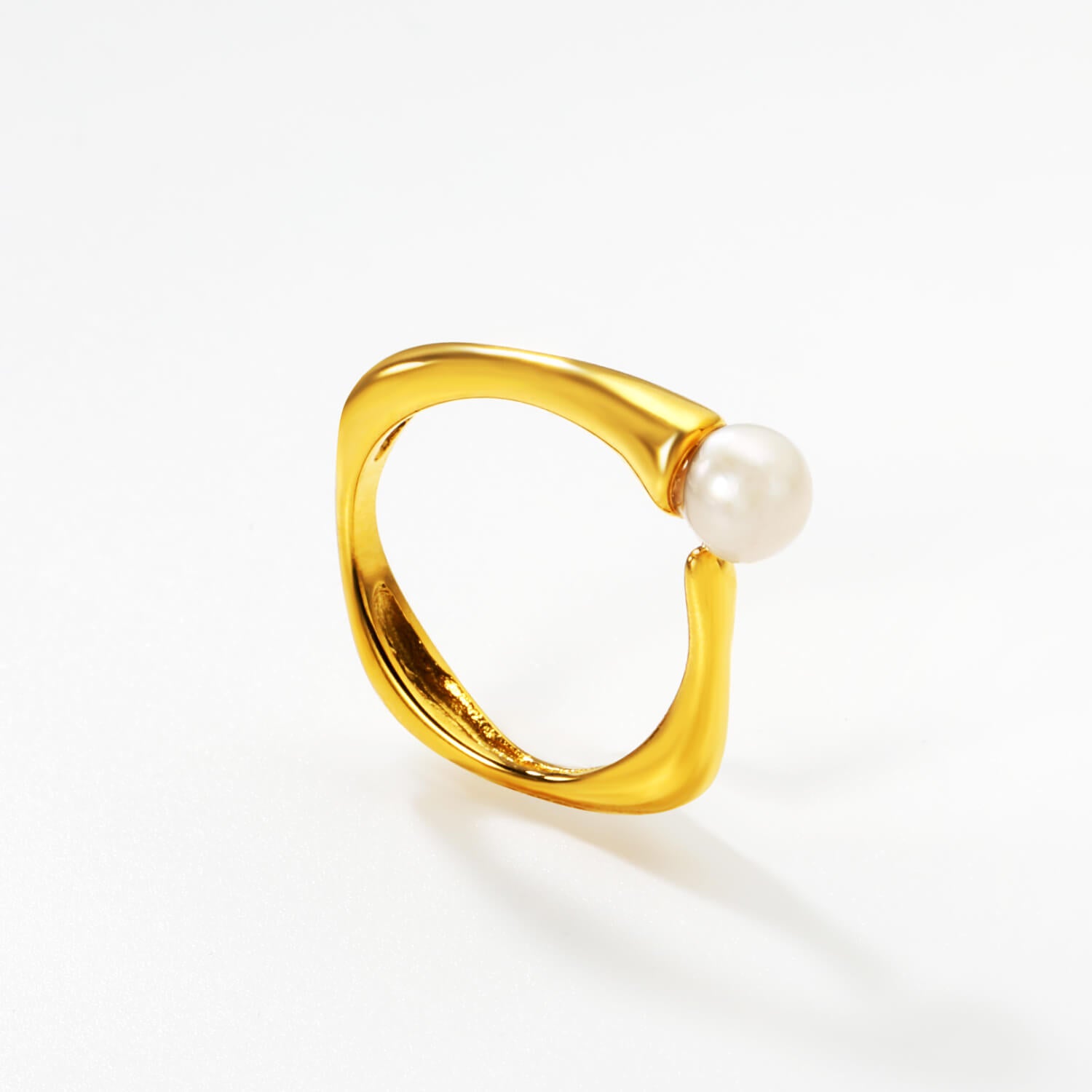 Helmisormus, valkoisella taustalla. Kultainen säädettävä sormus jossa yksi makeanvedenhelmi.