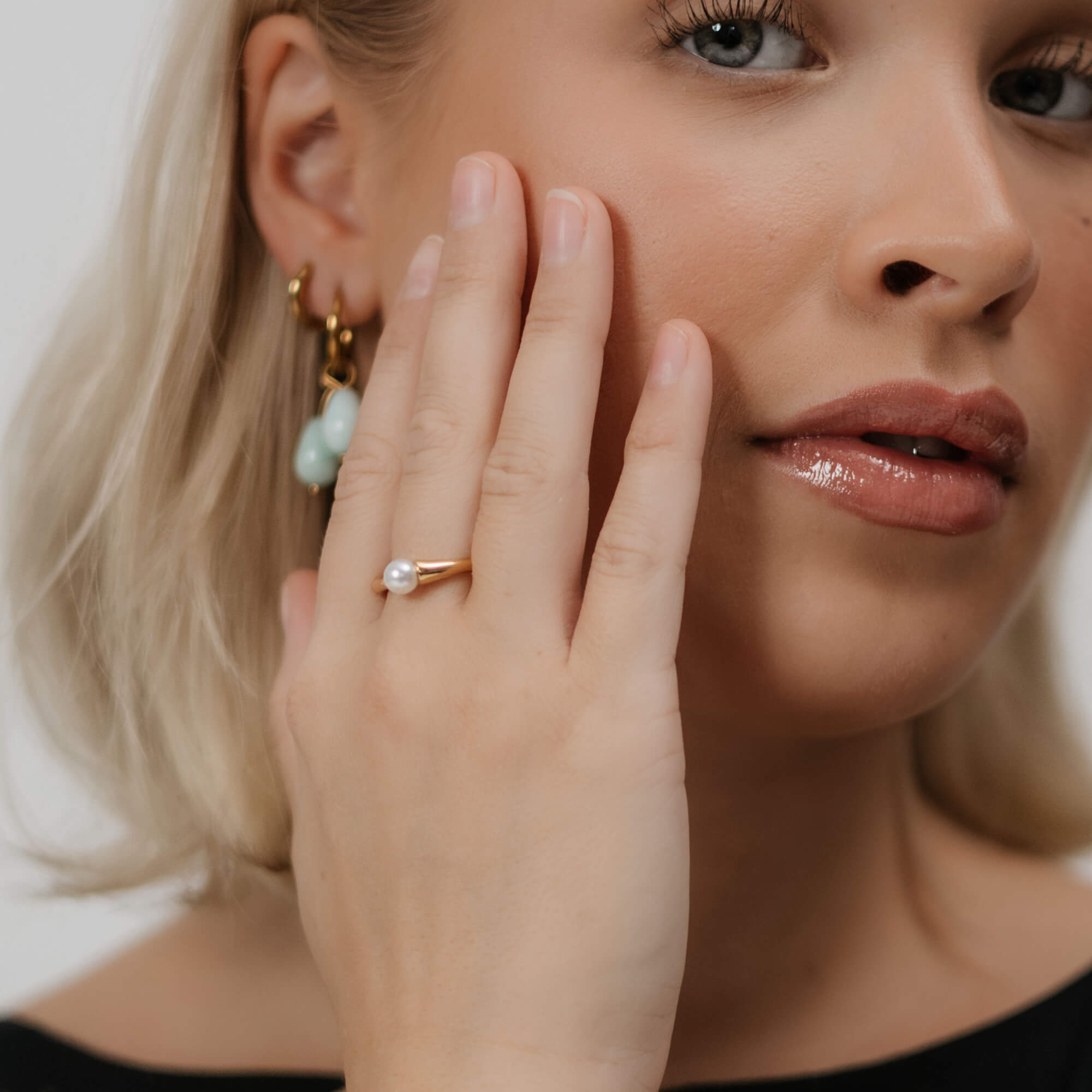 Kullattu helmisormus nuoren naisen sormessa