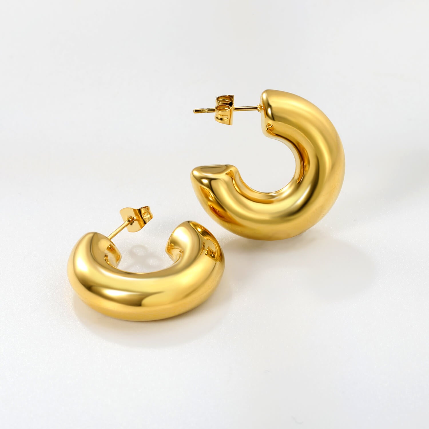 Vedenkestävät kullatut hypoallergiset chunky korvakorut valkoisella taustalla