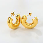 Kullatut chunky korvakorut valkoisella taustalla