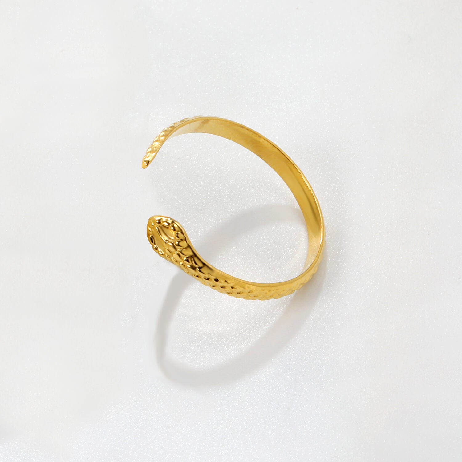 Madoww brändin Cobra vedenkestävä pvd-tekniikalla 18k kullattu sormus. Sormuksessa on kobran pää ja se on valkoista taustaa vasten.