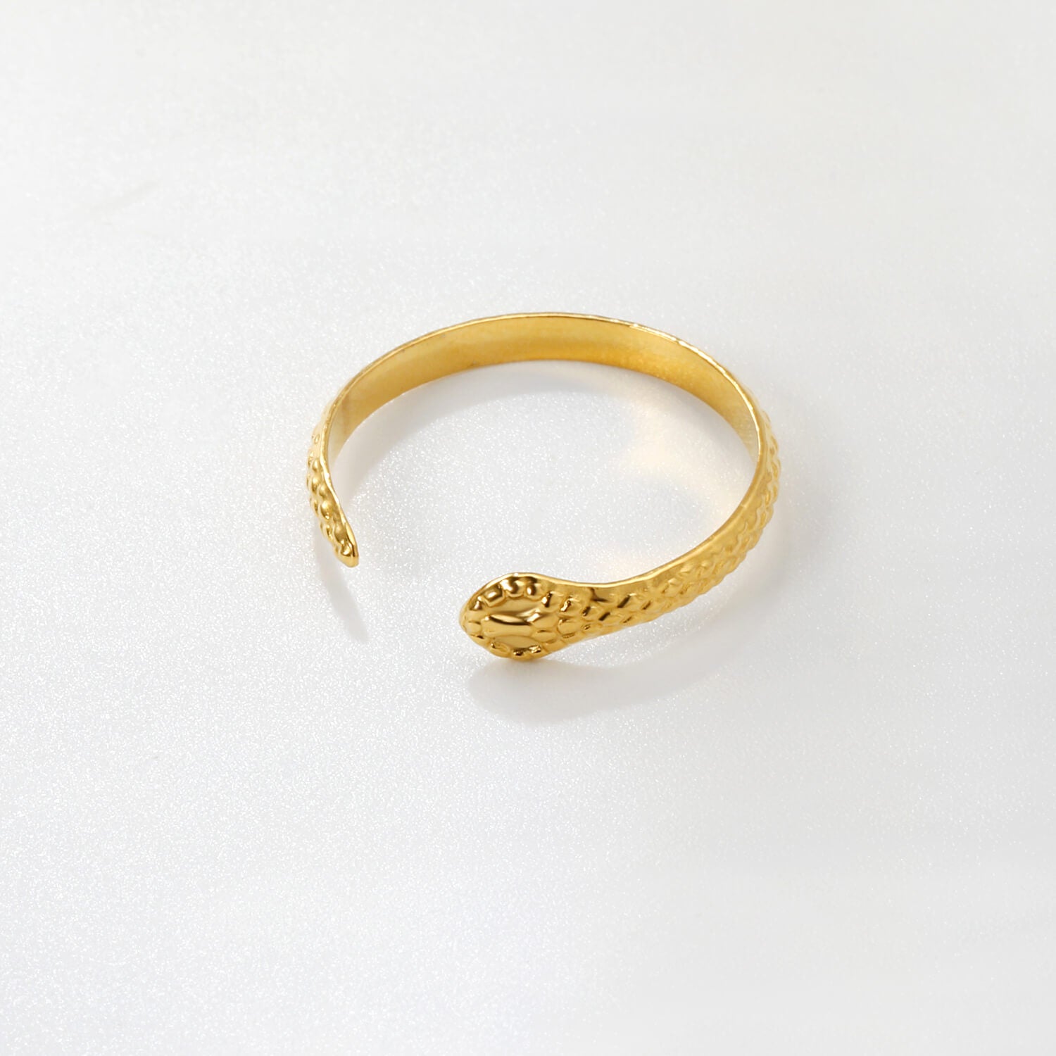 Madoww brändin Cobra vedenkestävä pvd-tekniikalla 18k kullattu sormus. Sormuksessa on kobran pää ja se on lappeellaan valkoista taustaa vasten.