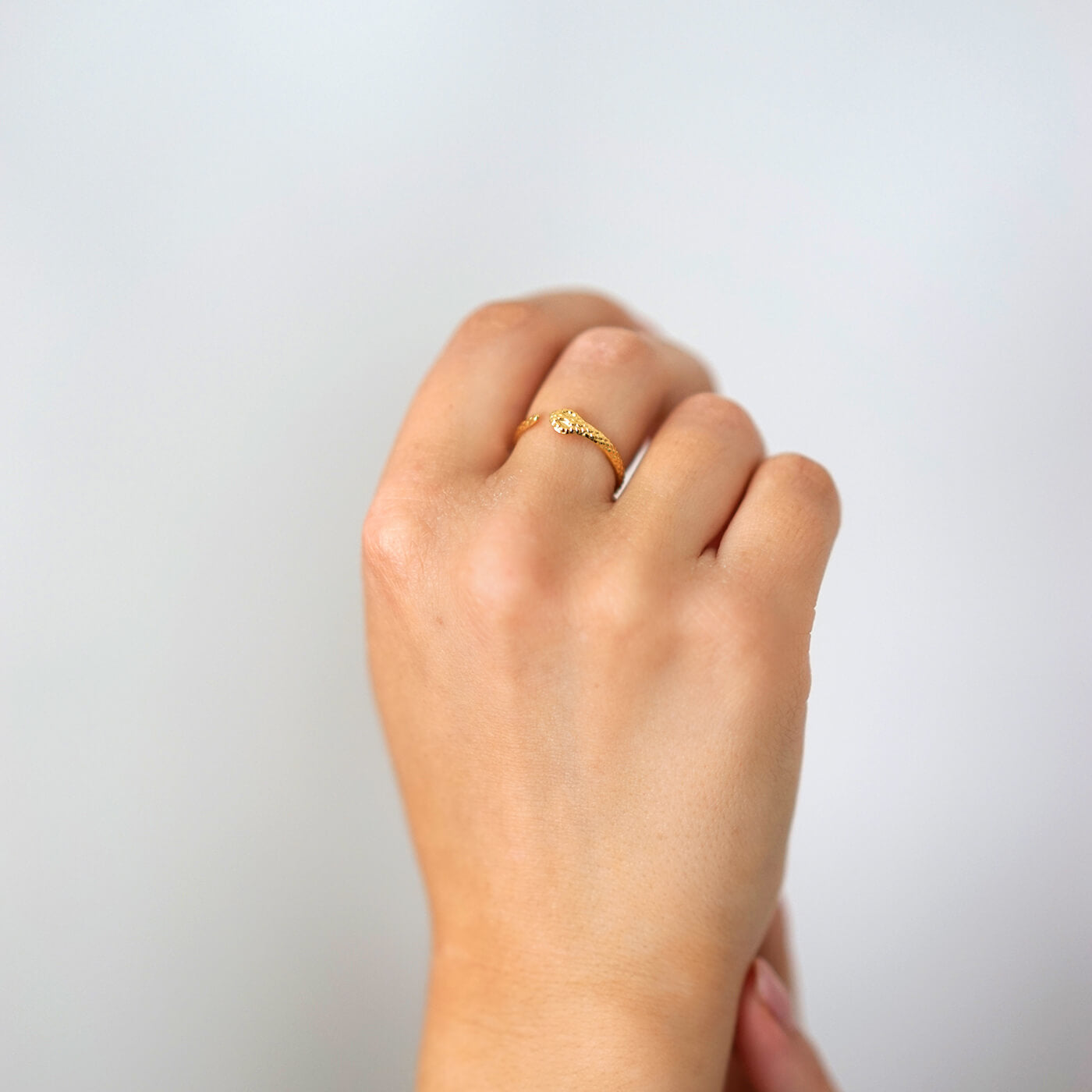 kullattu säädettävä käärme sormus naisen sormessa