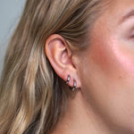 Hopeiset huggies korvakorut naisen päällä