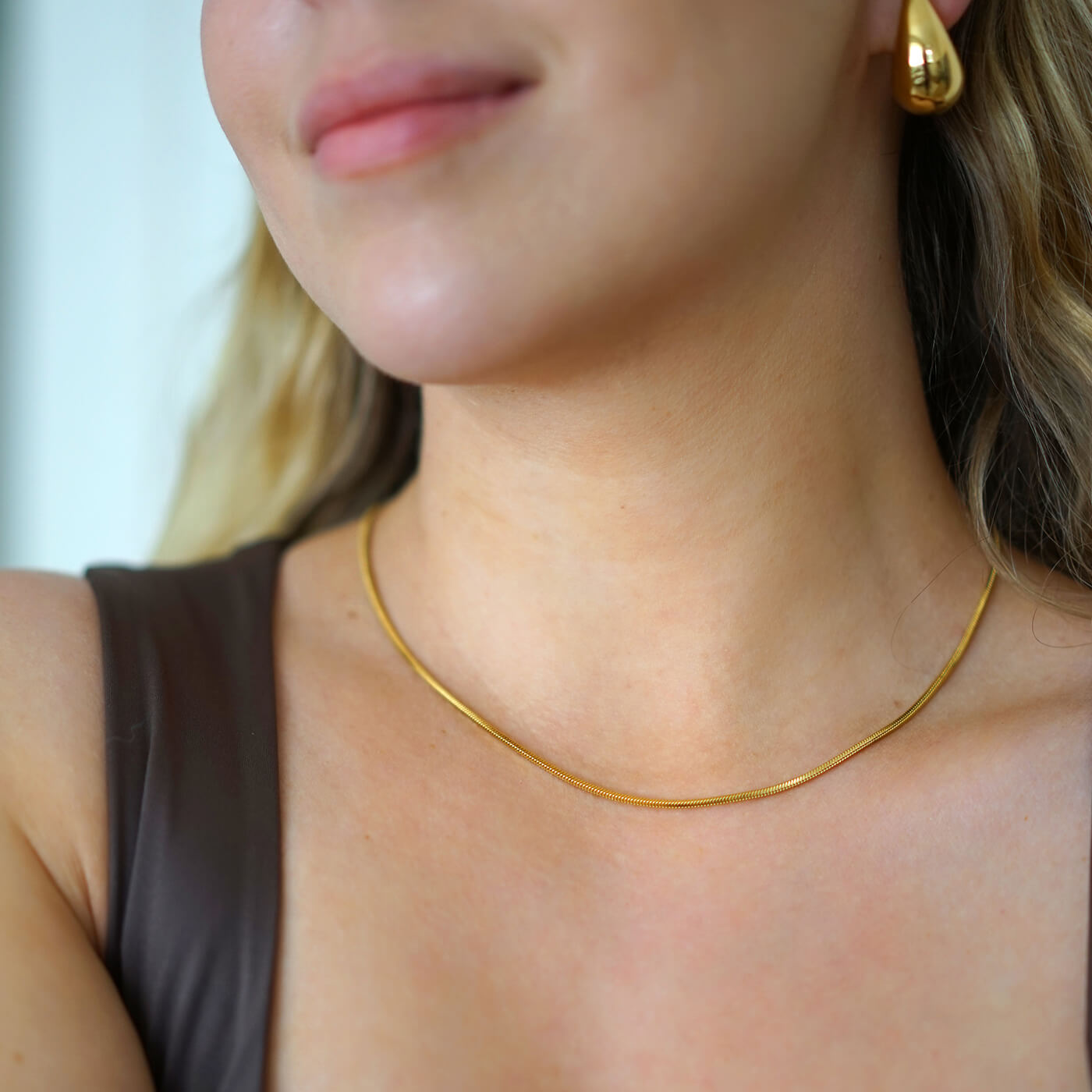 Kullattu vedenkestävä kaulakoru naisen kaulassa