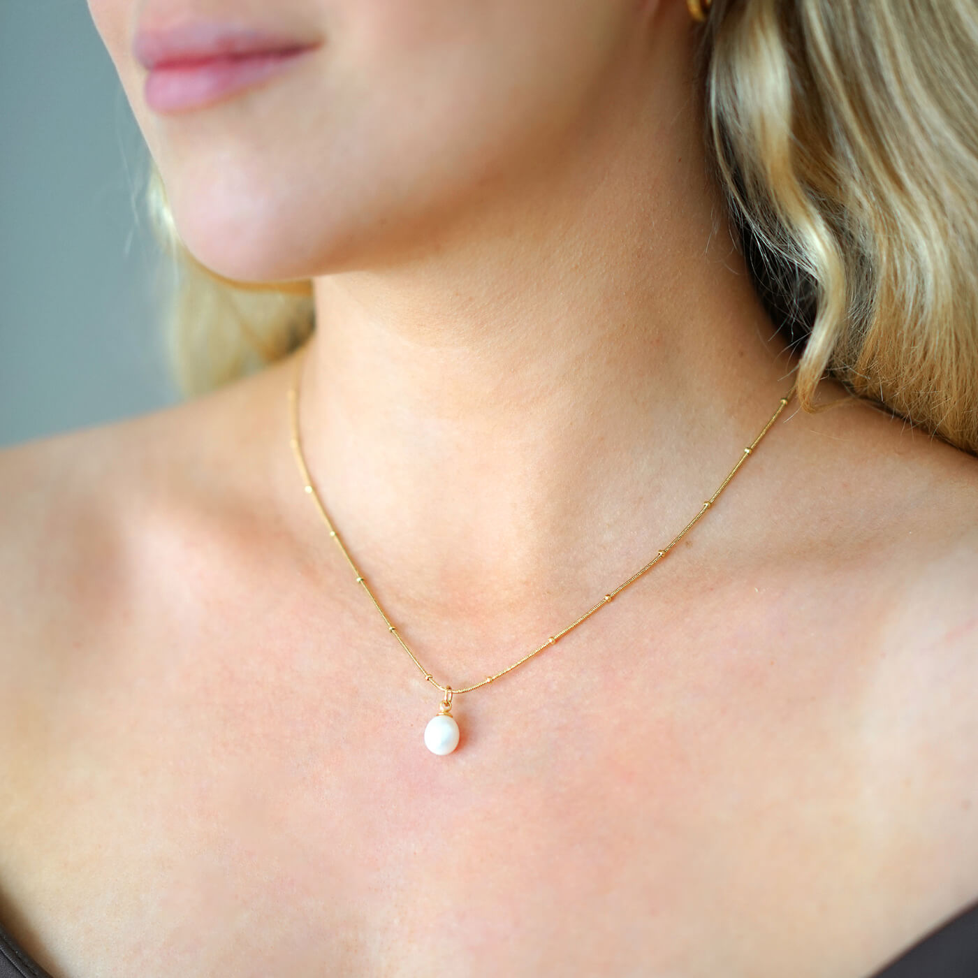 Kullattu vedenkestävä helmikaulakoru nuoren naisen kaulassa