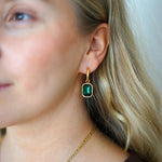 Vedenkestävät kullatut korvakorut zirkonilla nuoren naisen päällä