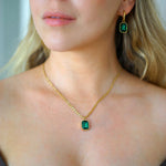 Kullattu kaulakoru ja korvikset zirkoneilla nuoren naisen yllä