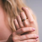 Kullattu helmisormus naisen kädessä