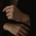 Kullattu rope chain rannekoru nuoren naisen kädessä. tunnelmallinen tummansävyinen kuva.