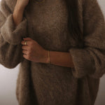 kultainen rannekoru nuoren naisen kädessä