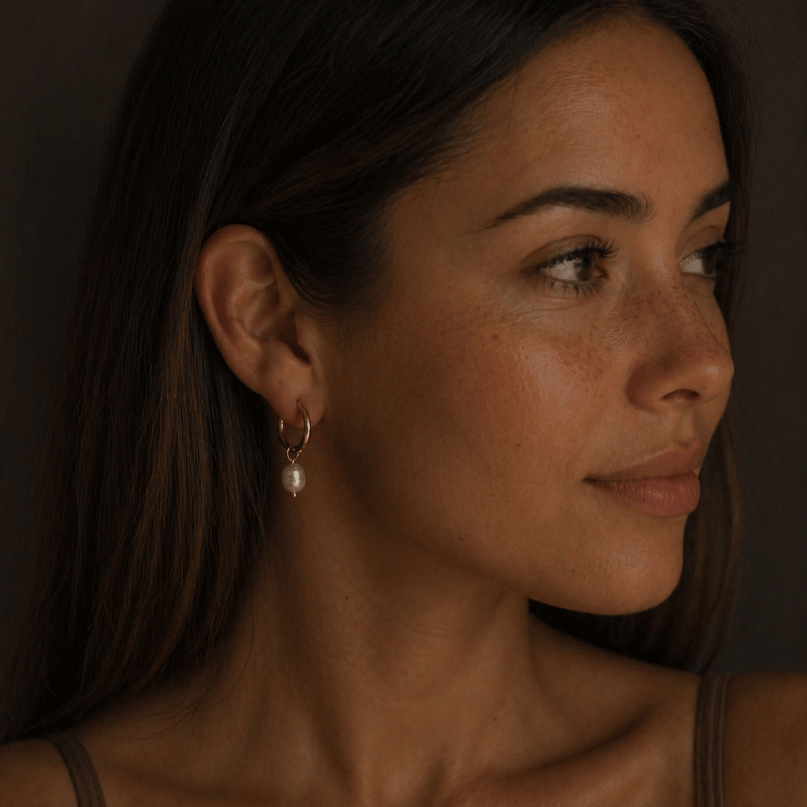 18K gold-plated hypoallergenic hoop earrings with a little pearl on a brown-haired woman. 