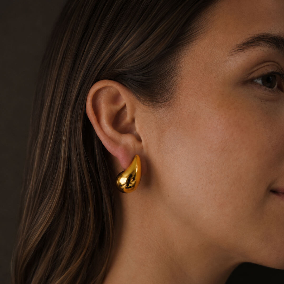 Dew Earring in gold on model’s ear, close-up from a different angle with soft warm lighting.
