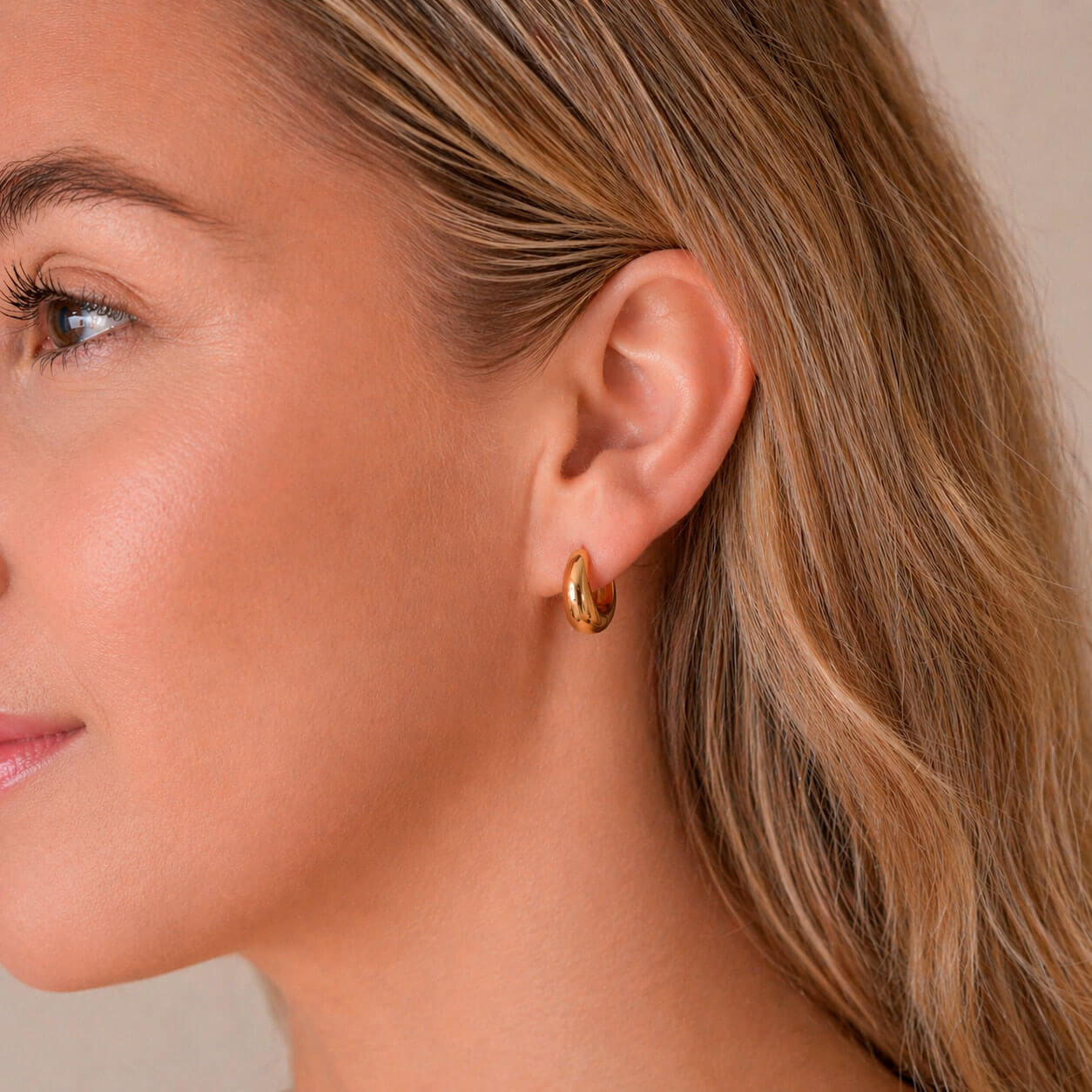 Kullatut madoww echo korvakorut naisen korvassa