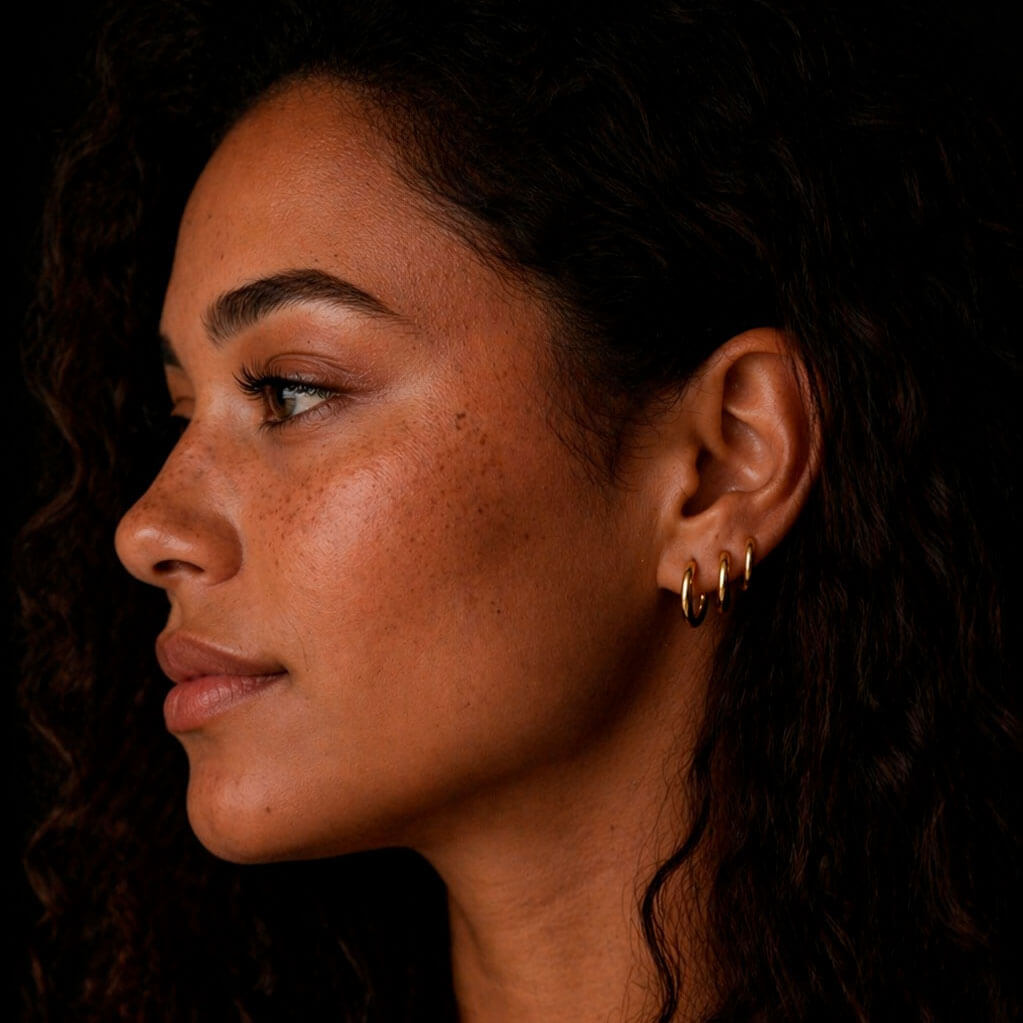 Three huggie earrings on a beatiful woman
