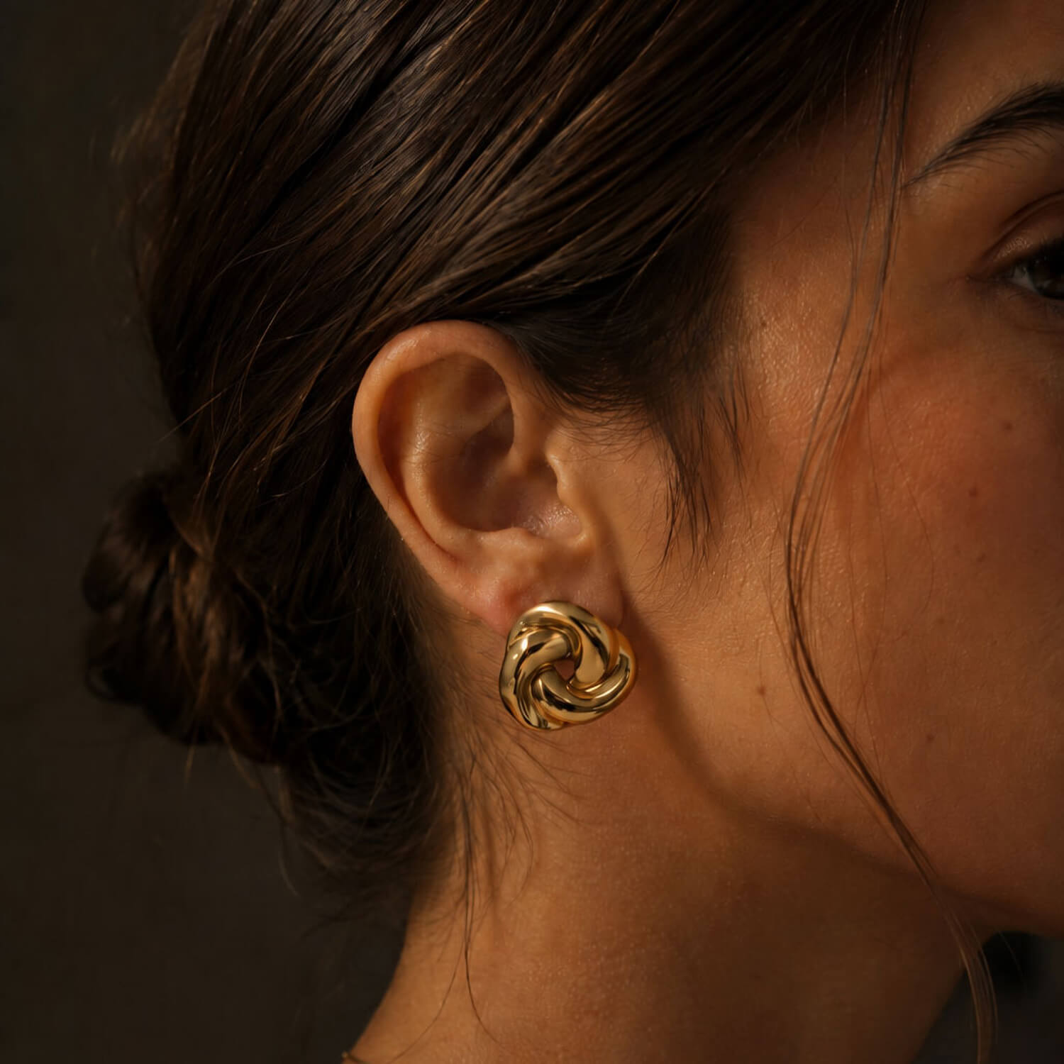 madoww Swirl waterproof earrings in 18k PVD gold-plated stainless steel worn on ear